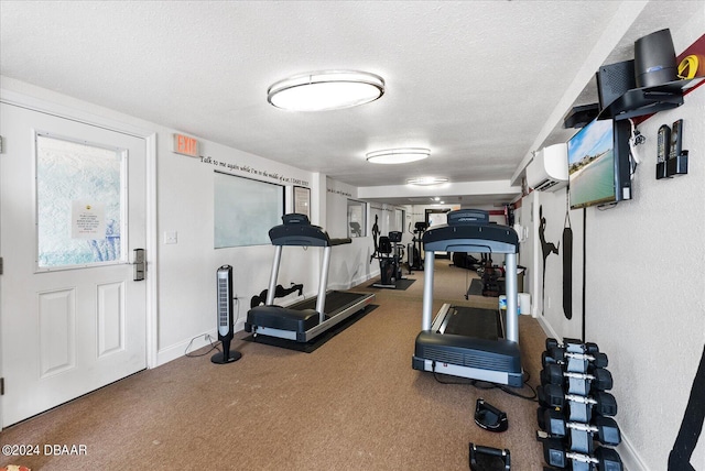 exercise area with carpet, a textured ceiling, and a wall unit AC