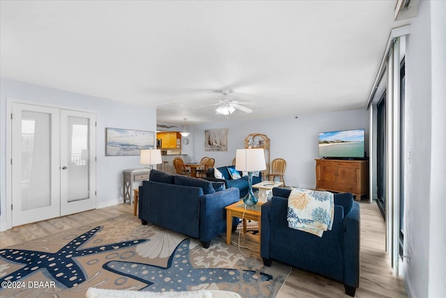 living room featuring ceiling fan, light hardwood / wood-style floors, and french doors