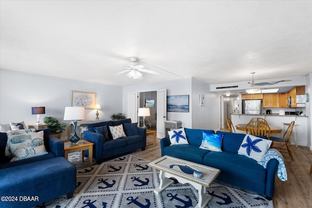 living room with ceiling fan and light wood-type flooring