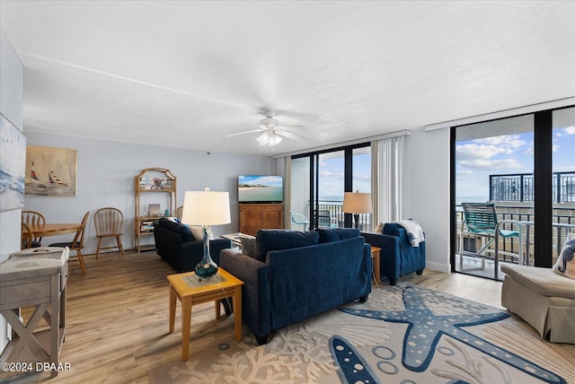 living room with light hardwood / wood-style flooring, expansive windows, and ceiling fan