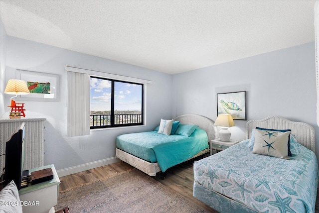 bedroom with hardwood / wood-style floors and a textured ceiling