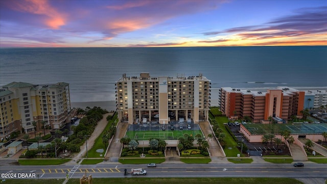 aerial view at dusk featuring a water view