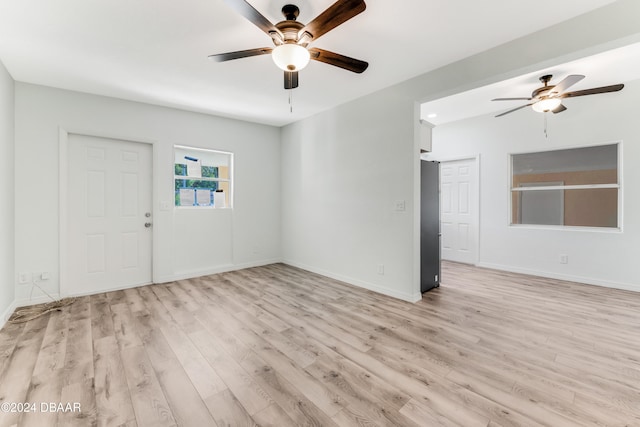 spare room with light wood-type flooring and ceiling fan