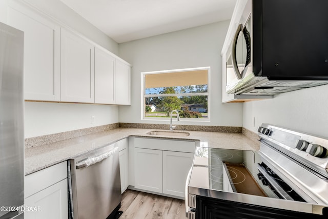 kitchen featuring stainless steel appliances, light hardwood / wood-style floors, white cabinets, and sink