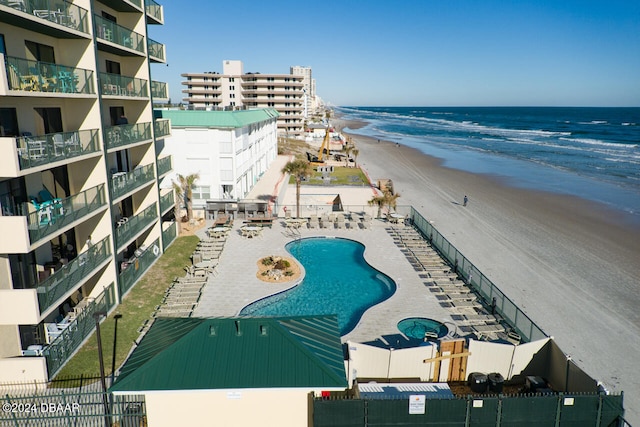 view of pool featuring a beach view, a patio, and a water view