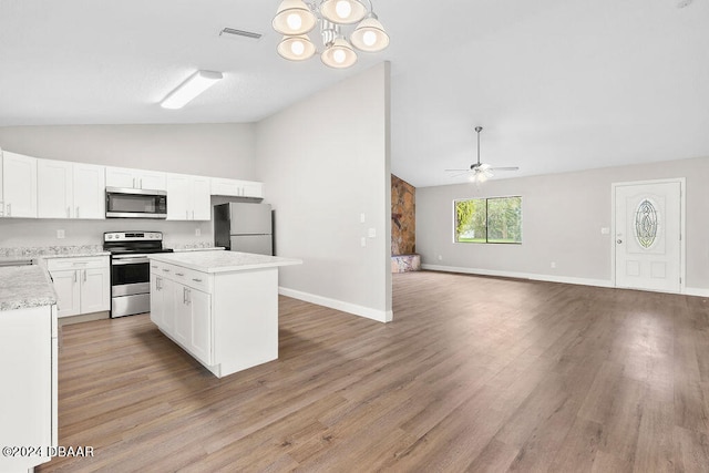 kitchen with light hardwood / wood-style floors, appliances with stainless steel finishes, lofted ceiling, a center island, and white cabinets