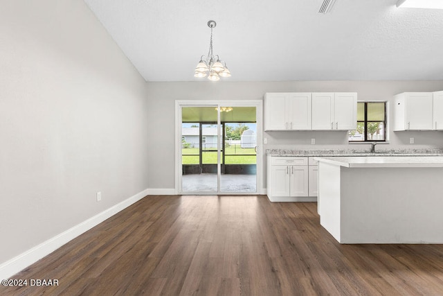 kitchen featuring dark wood-type flooring, white cabinetry, an inviting chandelier, and decorative light fixtures