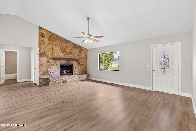 unfurnished living room with hardwood / wood-style floors, ceiling fan, a fireplace, and lofted ceiling