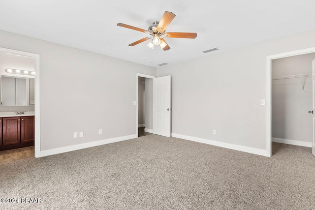 unfurnished bedroom featuring light carpet, ceiling fan, sink, and connected bathroom