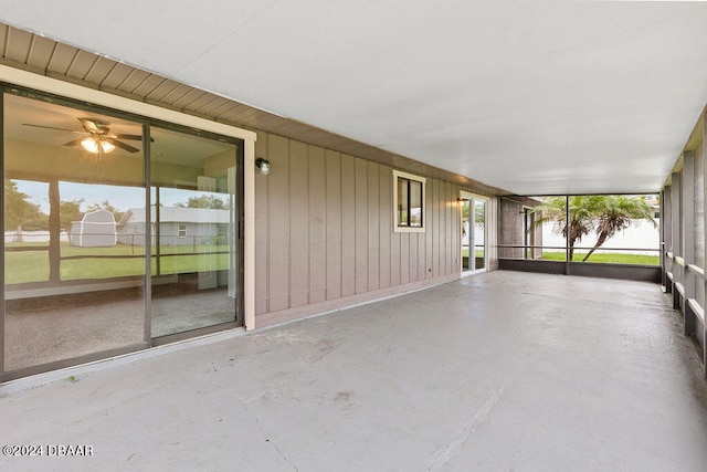 unfurnished sunroom featuring ceiling fan and plenty of natural light