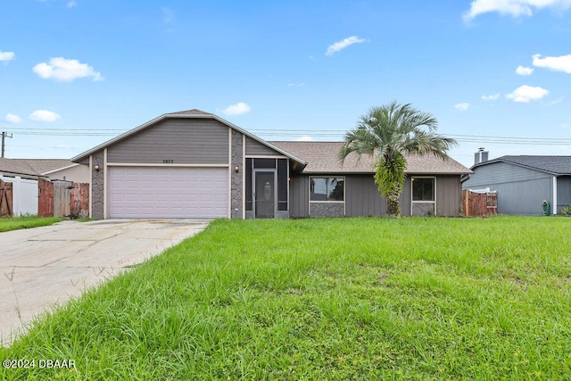 ranch-style home featuring a garage and a front lawn