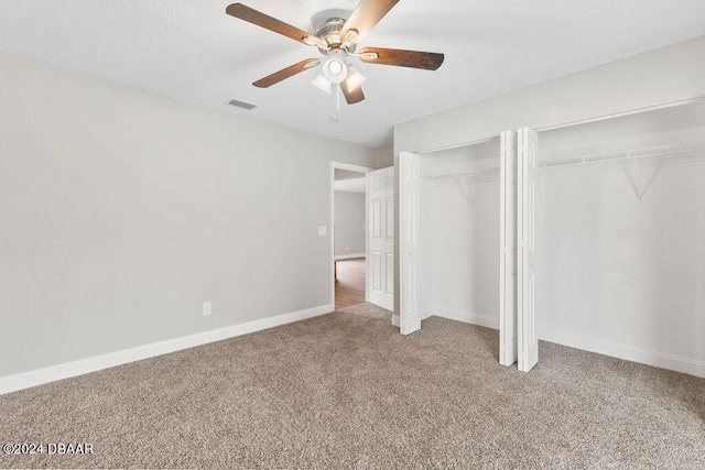 unfurnished bedroom featuring ceiling fan, carpet flooring, and two closets