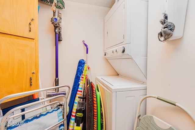 washroom featuring stacked washing maching and dryer