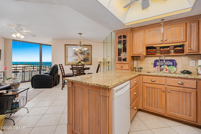 kitchen featuring backsplash, expansive windows, white dishwasher, a water view, and light tile patterned flooring