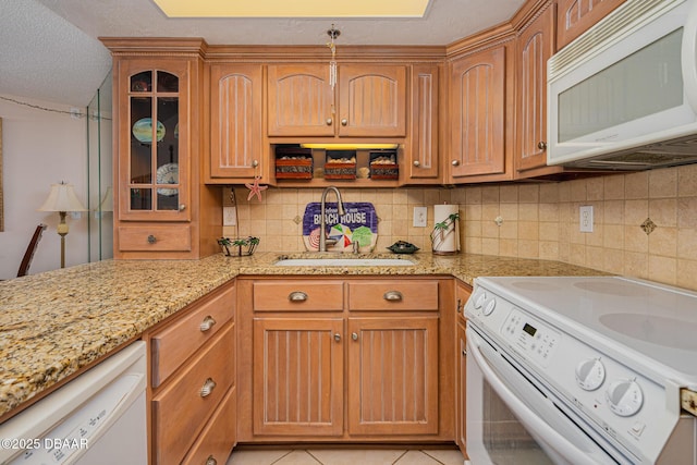 kitchen with white appliances, decorative backsplash, light tile patterned floors, a textured ceiling, and light stone counters