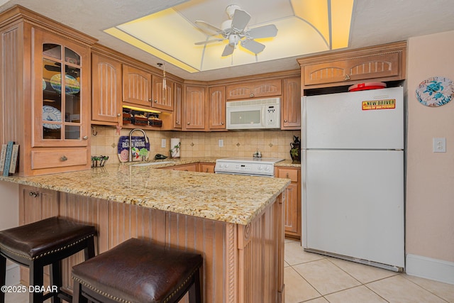 kitchen featuring kitchen peninsula, white appliances, ceiling fan, sink, and light tile patterned flooring