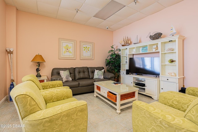 tiled living room featuring a drop ceiling