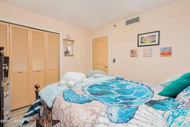 bedroom with a textured ceiling and a closet