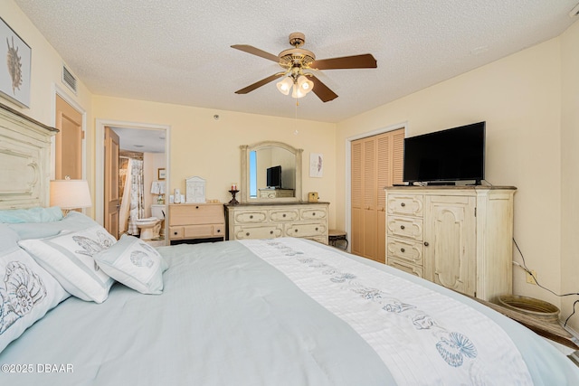 bedroom featuring a textured ceiling, a closet, ensuite bath, and ceiling fan