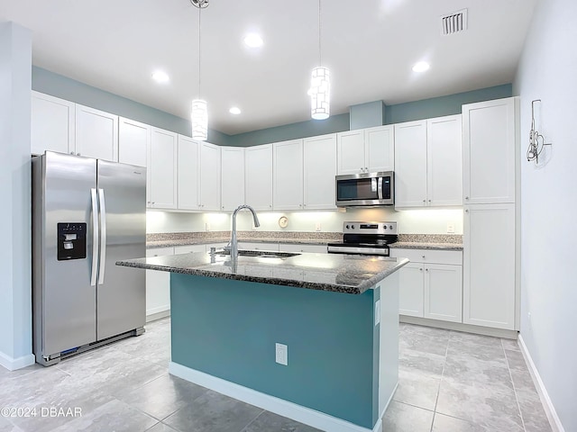 kitchen featuring pendant lighting, sink, an island with sink, appliances with stainless steel finishes, and white cabinetry