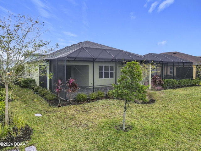 back of property featuring a lanai, a yard, and a patio