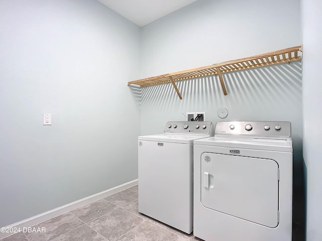 laundry room with washer and clothes dryer and light tile patterned floors