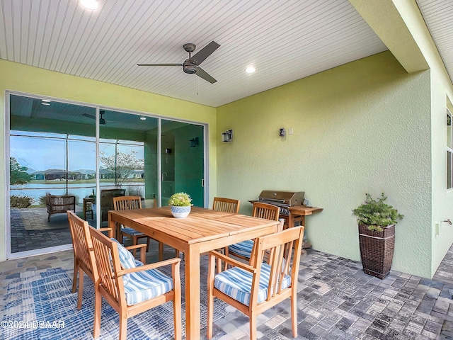 view of patio / terrace featuring a water view, area for grilling, and ceiling fan