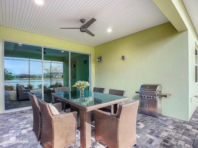 view of patio / terrace featuring ceiling fan, a grill, and a water view