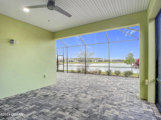 view of patio / terrace with a lanai, ceiling fan, and a water view