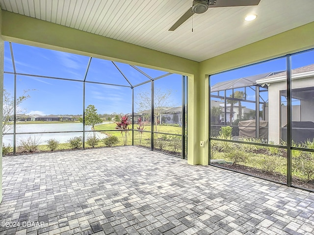 unfurnished sunroom featuring a water view and ceiling fan