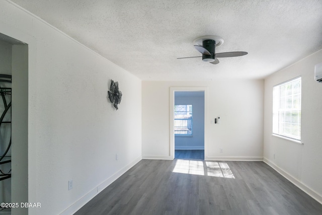 spare room featuring a textured ceiling, ceiling fan, and dark wood-type flooring