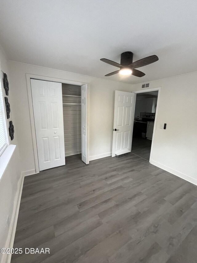 unfurnished bedroom with a closet, ceiling fan, and dark wood-type flooring