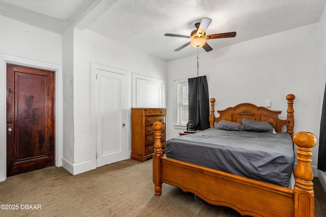 carpeted bedroom with a textured ceiling and ceiling fan