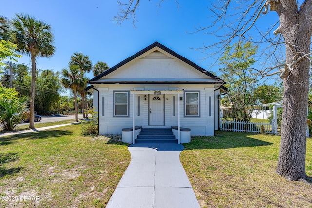 bungalow-style house with a front yard and fence