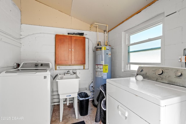 laundry room featuring electric water heater, concrete block wall, cabinet space, independent washer and dryer, and a sink