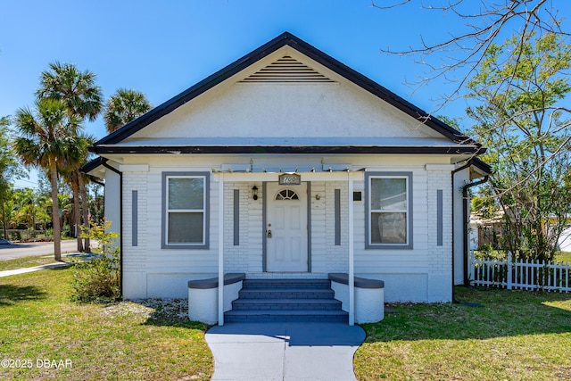 bungalow with entry steps, a front yard, and fence