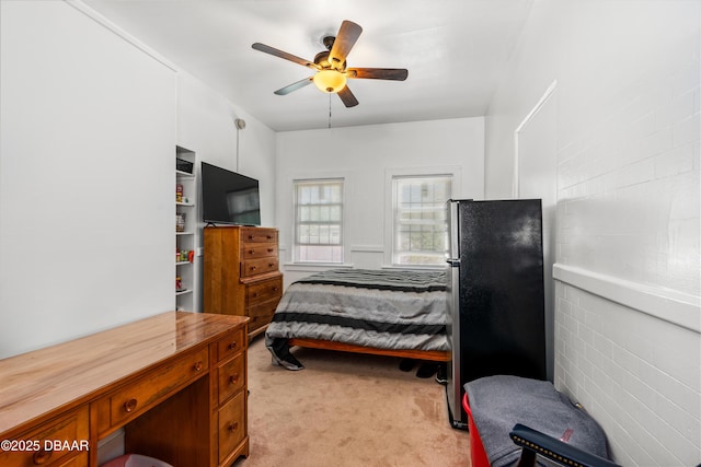 bedroom with light colored carpet, a ceiling fan, and freestanding refrigerator