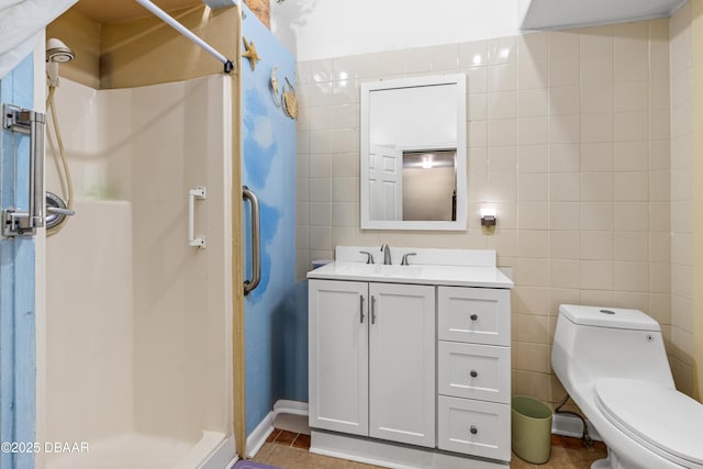 full bath with toilet, tile walls, a stall shower, and vanity