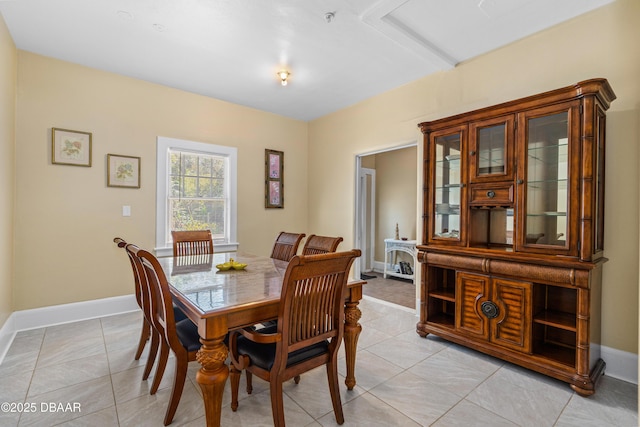 dining space with light tile patterned floors and baseboards