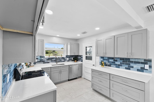 kitchen featuring appliances with stainless steel finishes, sink, decorative backsplash, and gray cabinetry