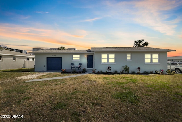 view of front of home with a garage and a lawn