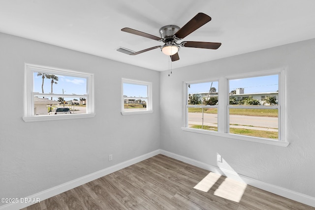 empty room with ceiling fan and light hardwood / wood-style floors