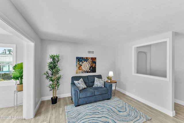 sitting room featuring light hardwood / wood-style floors and a textured ceiling