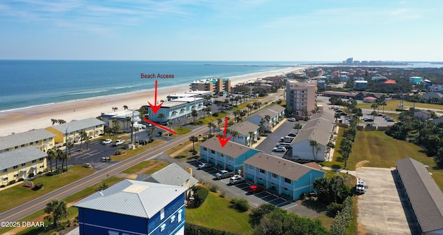 drone / aerial view featuring a beach view and a water view