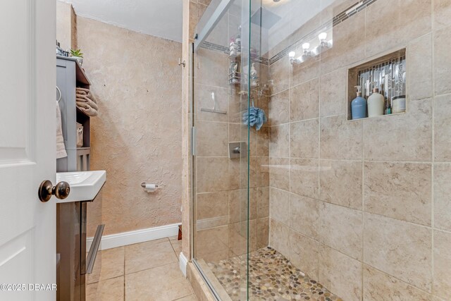 532 Lafayette St, Port Orange, FL 32127 - bathroom featuring baseboards, a stall shower, tile patterned floors, and a textured wall