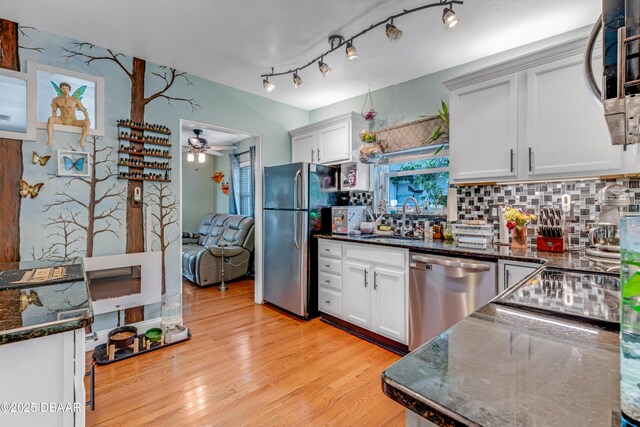 532 Lafayette St, Port Orange, FL 32127 - kitchen with appliances with stainless steel finishes, a sink, decorative backsplash, light wood-style floors, and a ceiling fan