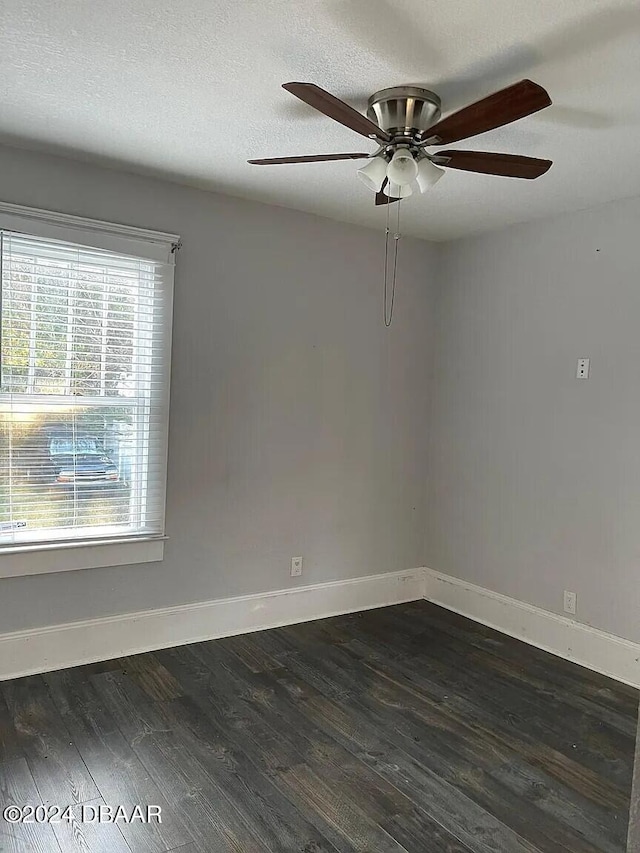 unfurnished room featuring ceiling fan, dark wood-type flooring, and a textured ceiling