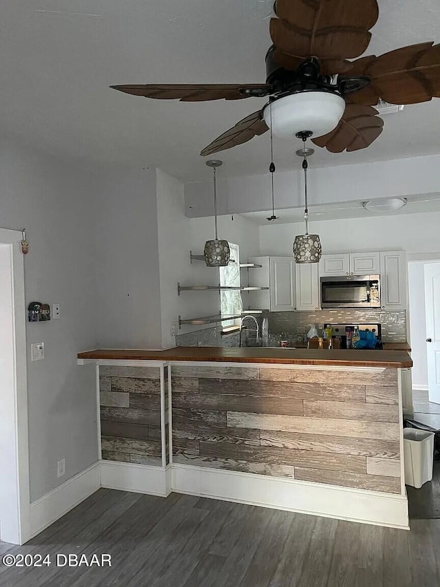 bar featuring dark hardwood / wood-style flooring, tasteful backsplash, sink, white cabinets, and hanging light fixtures