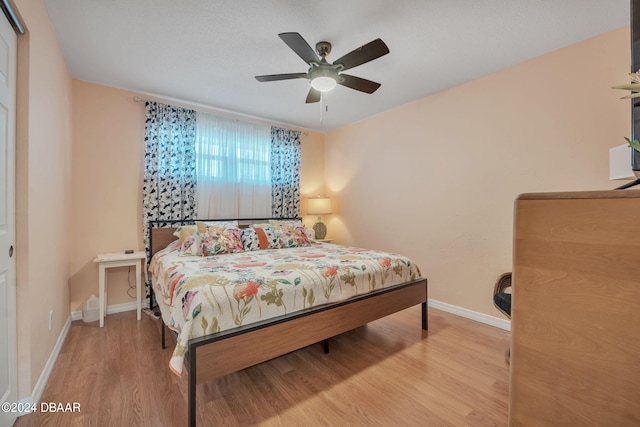 bedroom with ceiling fan and light hardwood / wood-style floors