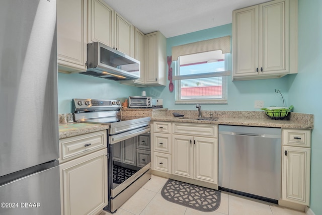 2901 N Halifax Ave Unit 218, Daytona Beach, FL 32118 - kitchen featuring appliances with stainless steel finishes, light tile patterned floors, cream cabinetry, and light stone countertops